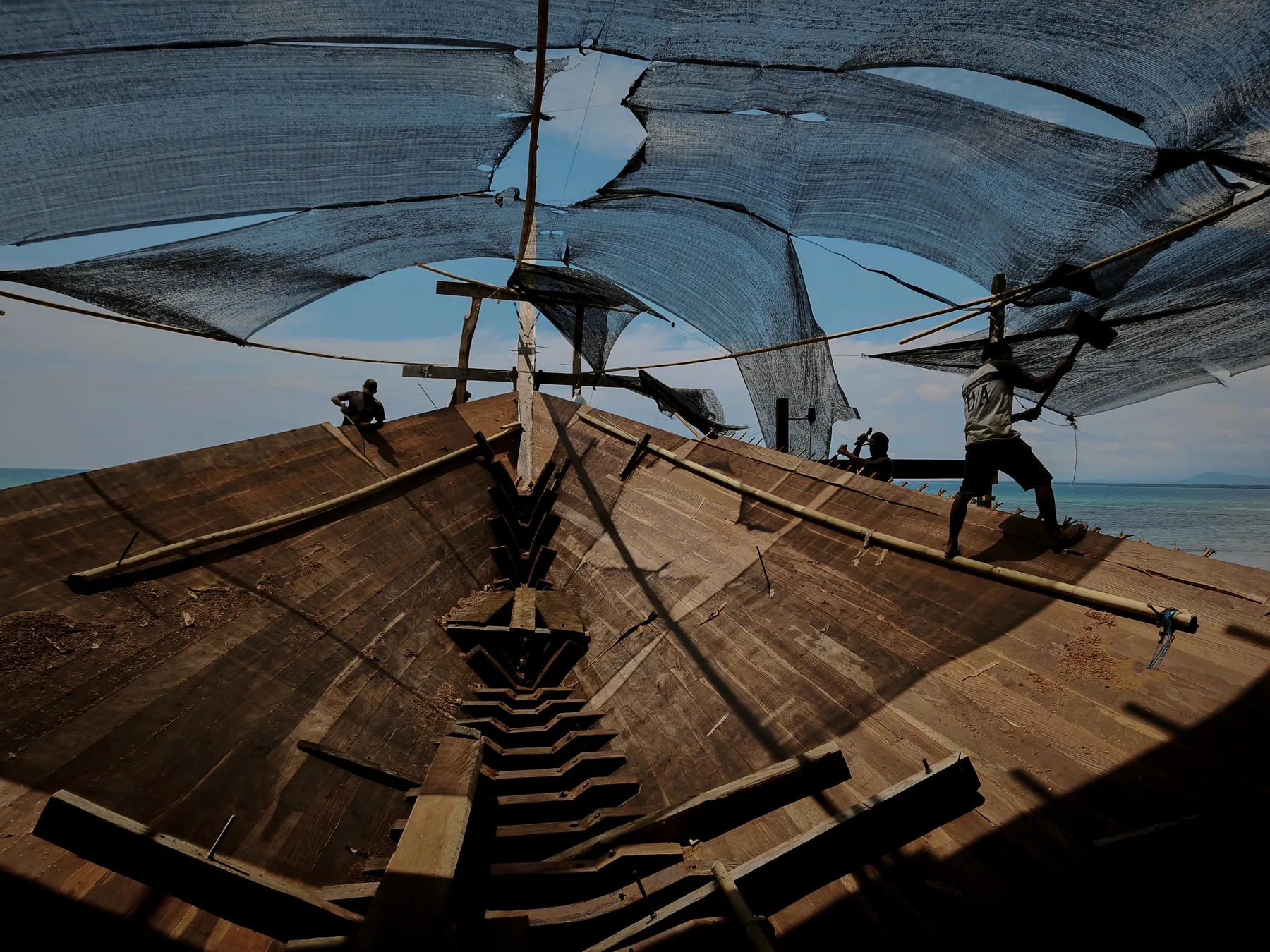 Waow 2's hull under shade nets, built from Indonesian wood.